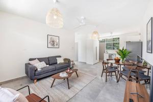 a living room with a couch and a table at 'Botanica Bonita' A Stylish Nightcliff Hideaway in Darwin