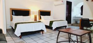 um quarto de hotel com duas camas e uma mesa em Hotel Boutique Plaza Doradas em San José del Cabo
