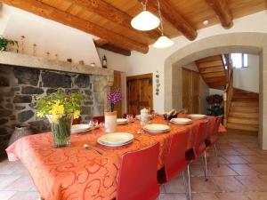 a dining room with a long table with red chairs at Ferme restaurée avec jardin clos et terrasse, proche Puy en Velay - FR-1-582-271 in Le Monastier sur Gazeille +28 photos