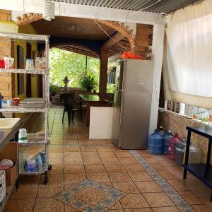 a kitchen with a refrigerator on a tile floor at Hotel & Hostal Mayflower in Puerto Escondido