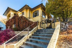 une maison jaune avec des escaliers devant elle dans l'établissement Stunning View, Frank Lloyd Wright Inspired Home!, à Salt Lake City