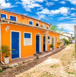 un edificio naranja con puertas azules en una calle en Pousada Nativos - Centro Histórico, en Lençóis