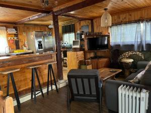 Una cocina y una sala de estar con un sofá y una mesa. en Cabañas Hostal Punta de Lobos Surf & Relax, en Pichilemu
