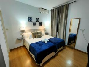 1 dormitorio con 1 cama grande y espejo en Hotel Zaida, en Sevilla