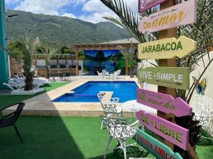 a resort with a swimming pool with chairs and a sign at A-1 Hermoso Apartamento tipo villa al pie de la montaña elitevillasjarabacoa in Jarabacoa