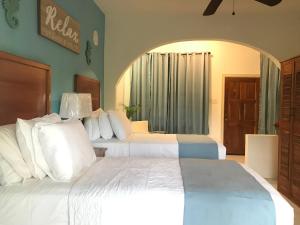 a hotel room with two beds with white pillows at Sommerville Resorts in Negril