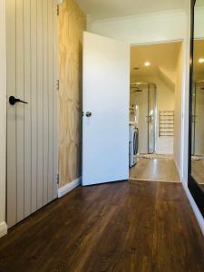 an empty room with a white door and wooden floors at Lux Studio in Dunedin Central in Dunedin