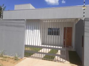een wit hek voor een gebouw bij Casa Nova confortavel e aconchegante 1 in Chapada dos Guimarães