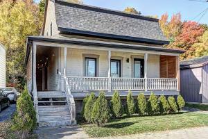 Casa blanca con porche y escalera en Confo27 Chute-Montmorency, en Quebec