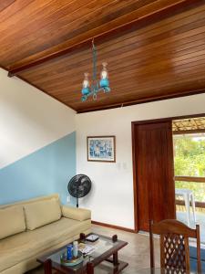 a living room with a couch and a wooden ceiling at Casa paradise perto da praia Guarajuba - BA in Camacari
