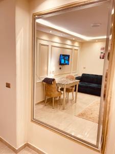 einen Spiegel in einem Zimmer mit einem Tisch und einem Sofa in der Unterkunft El mansour hotel apartmen 91 in Mansoura