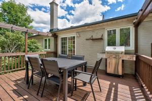 a patio with a table and chairs on a deck at Bungalow-3 Car Parking-PingPong-BigDeck-BBQ-Close to 403-Appleby Go in Burlington