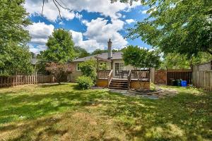 a house with a fence and a yard at Bungalow-3 Car Parking-PingPong-BigDeck-BBQ-Close to 403-Appleby Go in Burlington