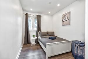 a small bedroom with a bed with a window at Bungalow-3 Car Parking-PingPong-BigDeck-BBQ-Close to 403-Appleby Go in Burlington