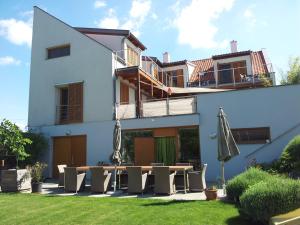 ein Haus mit einem Tisch und Stühlen im Hof in der Unterkunft SCHEIBER Wein & Gästehaus in Weiden am See