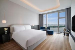 a bedroom with a white bed and a large window at Hotel Naru Seoul MGallery Ambassador in Seoul
