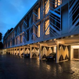 a building with a car parked in a parking lot at Lucky Hotel Bangkok in Khlong Toei