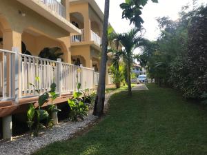 a house with a white fence next to a yard at Sommerville Resorts in Negril