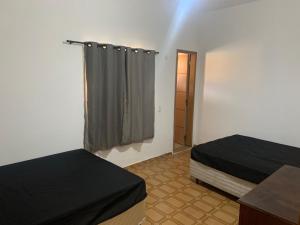 Tempat tidur dalam kamar di Casa Com Piscina a 3 Quadras da Praia da Vila