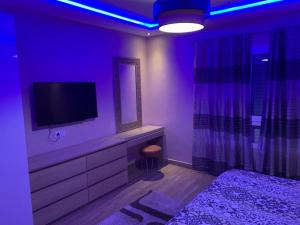 um quarto com uma televisão, uma cama e um espelho em Luxury Appartement Marina Agadir em Agadir
