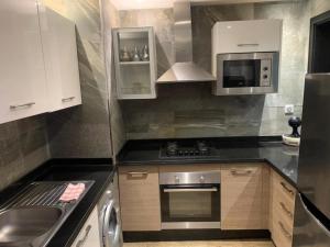 uma cozinha com um fogão e um micro-ondas em Luxury Appartement Marina Agadir em Agadir