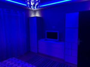 um quarto azul com uma televisão numa cómoda e uma luz azul em Luxury Appartement Marina Agadir em Agadir