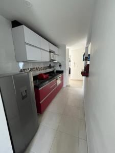 a kitchen with a stainless steel refrigerator and red cabinets at Apartamento Amoblado Villeta in Villeta