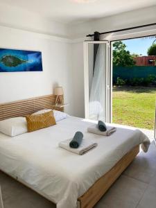 una camera da letto con un grande letto con asciugamani di Magnifique villa avec piscine privative et jardin a Saint-François