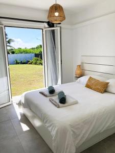 una camera da letto con un grande letto bianco con una grande finestra di Magnifique villa avec piscine privative et jardin a Saint-François