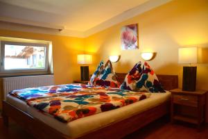 a bedroom with a bed with a colorful comforter at Pension Milan in Zell am See
