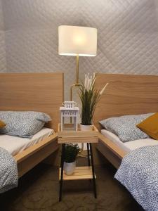 ein Schlafzimmer mit 2 Betten und einem Tisch mit einer Lampe in der Unterkunft Seaside Glamping@Heritage Chalet in Singapur