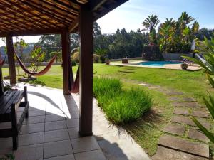 a patio with a hammock and a yard at Pousada Por Do Sol chalés Monte Verde in Monte Verde