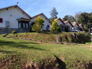 a house with a grassy hill in front of it at Pousada Por Do Sol chalés in Monte Verde
