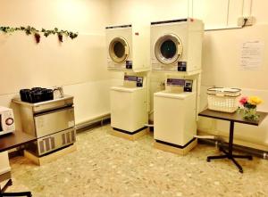 a laundry room with three washing machines and a table at Hotel Nakamuraya in Shiojiri