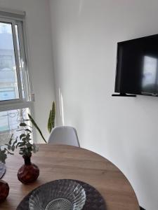 a wooden table with a vase on it with a television at SAN LUIS CENTRO Departamento monoambiente in San Luis