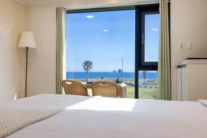 a bedroom with a bed and a view of the ocean at Sun and Moon Resort in Seogwipo