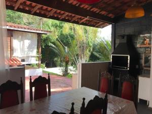 a dining room with a table and chairs and a television at Linda Chácara com Piscina in Arujá