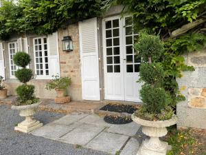 ein Haus mit einer weißen Tür und einigen Pflanzen in der Unterkunft Chateau La Rametiere in Plomb