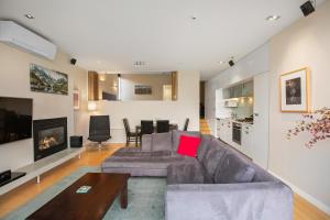 een woonkamer met een bank en een tafel bij Manaru Villa in Queenstown