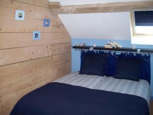 ein Schlafzimmer mit einem Bett mit einer Holzwand in der Unterkunft Gîte Douchy-Montcorbon-Douchy, 3 pièces, 5 personnes - FR-1-590-105 