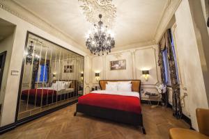 a bedroom with a red bed and a chandelier at Nordstern Hotel Galata in Istanbul