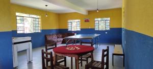 a room with a table and chairs and a couch at Chácara Sorriso 1 em Atibaia in Atibaia