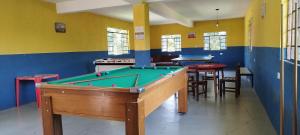 a billiard room with a pool table and tables at Chácara Sorriso 1 em Atibaia in Atibaia