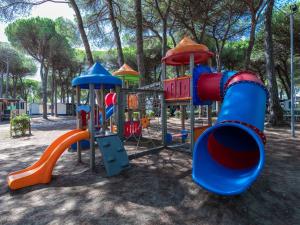 a playground in a park with a slide at Nice chalet in a pine forest near the Adriatic sea in Cesenatico