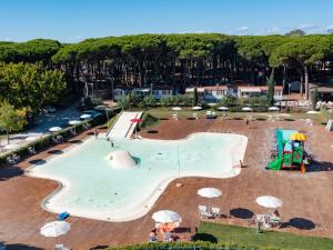 una grande piscina con scivolo e parco giochi di Nice chalet in a pine forest near the Adriatic sea a Cesenatico