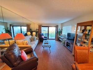 una sala de estar con una persona sentada en un sofá en Summerhouse 251 Condo, en St. Augustine