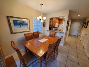 Un comedor y una cocina con mesa y sillas de madera. en Summerhouse 251 Condo, en St. Augustine