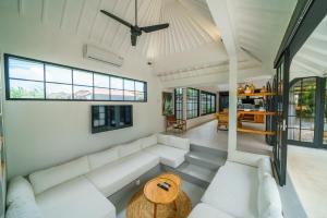 チャングーにあるVilla Mellow - Lovely 2 bdr villa close to the beach in Canggu !のリビングルーム(白い家具、天井ファン付)