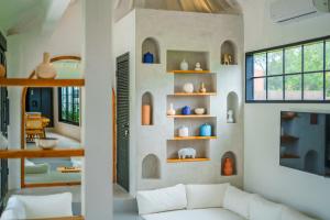 チャングーにあるVilla Mellow - Lovely 2 bdr villa close to the beach in Canggu !のリビングルーム(ソファ、花瓶棚付)
