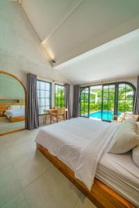 チャングーにあるVilla Mellow - Lovely 2 bdr villa close to the beach in Canggu !の大きなベッドルーム(大型ベッド1台、プール付)